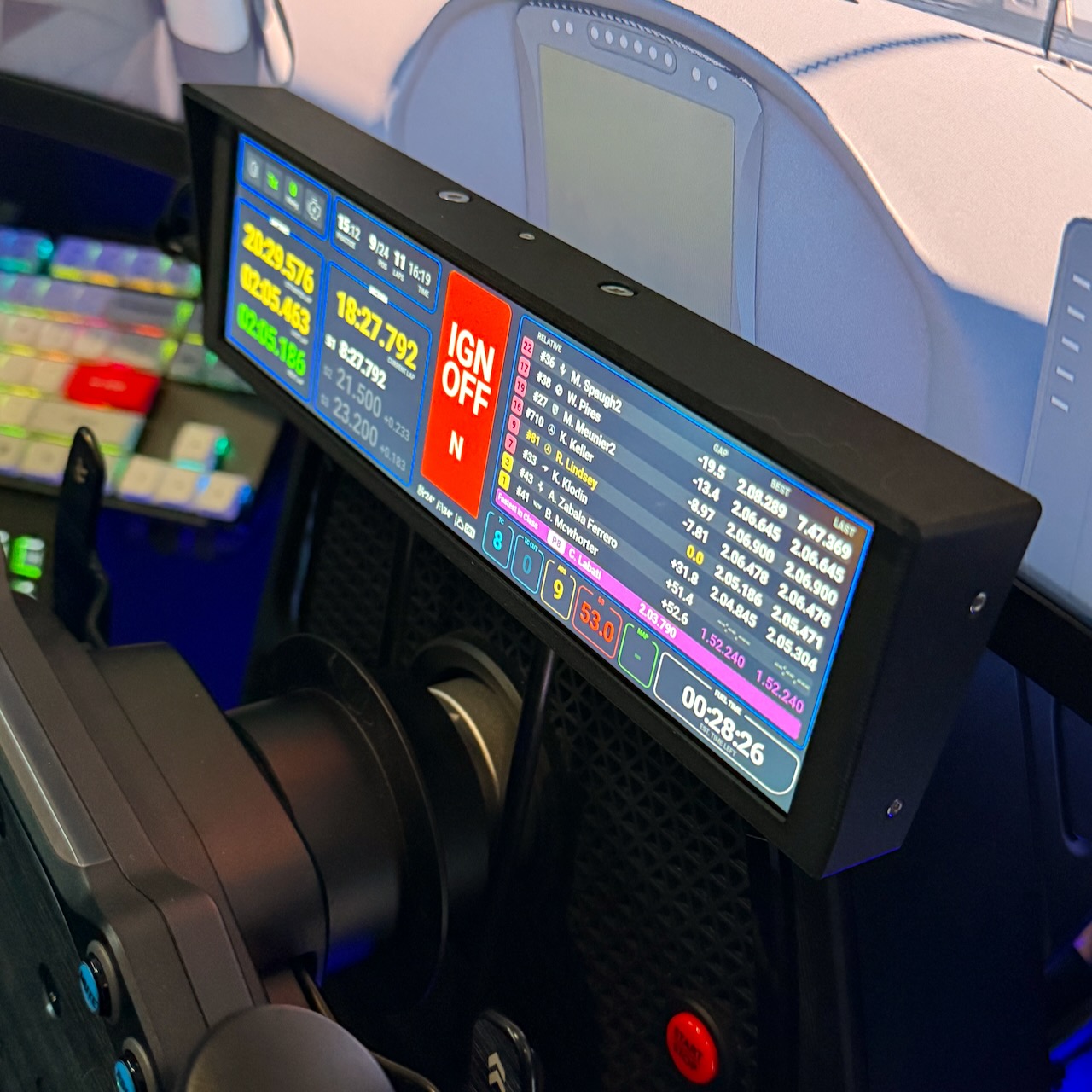 UXL Dashboard PRO mounted in-rig, screen on with live iRacing telemetry — relative timing, lap deltas, ignition state.